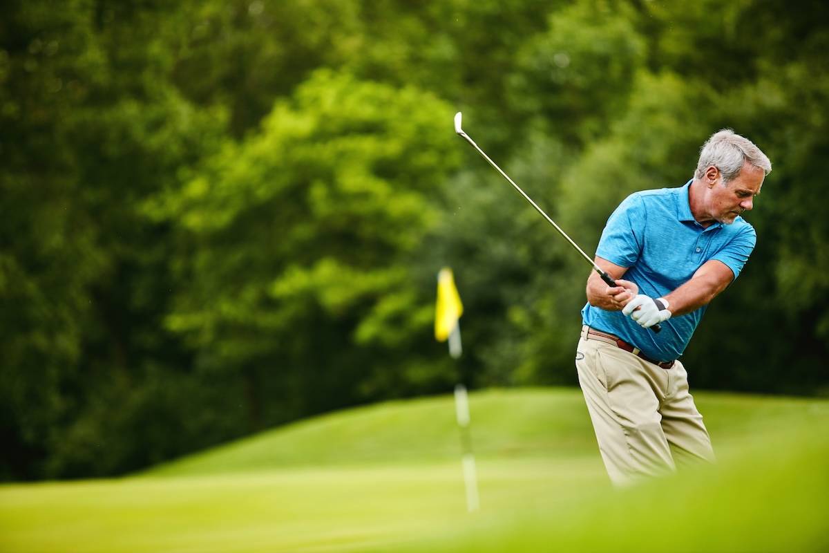 Mature man, sports and swing at golf course with hobby or activity for retirement and fun. Elderly person, break and play at field or club for fitness, training and exercise for health and recreation